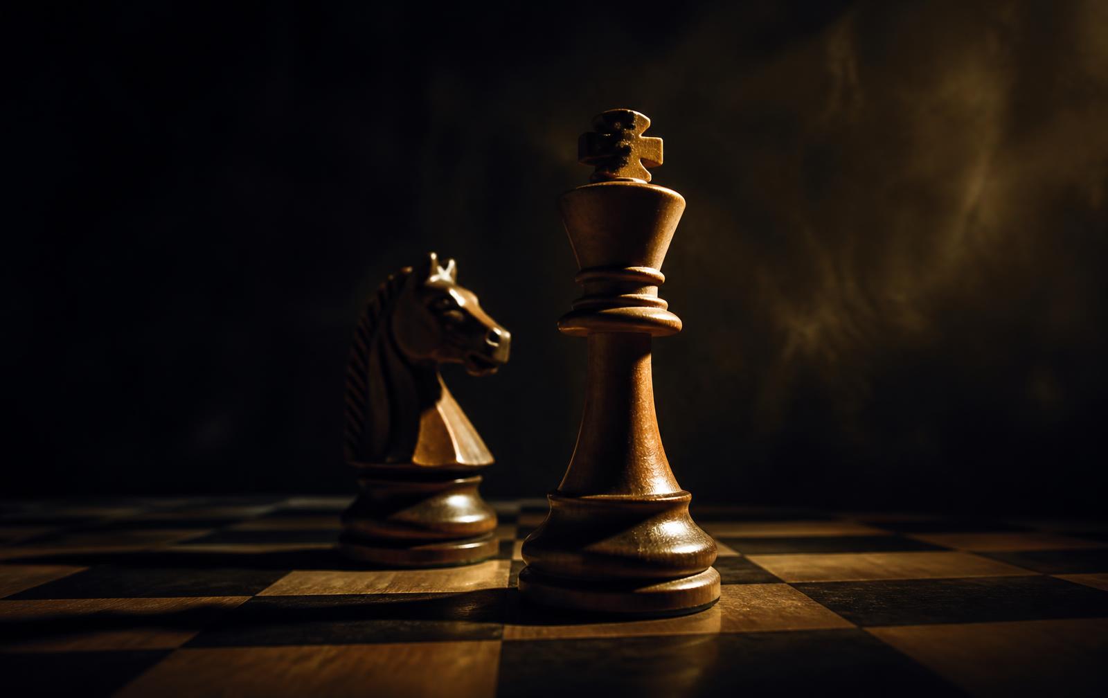 Chess king and knight on a wooden board under warm spotlight